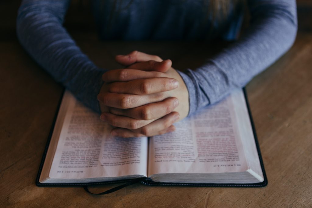 woman's hands on Bible. God Hears ours prayers
