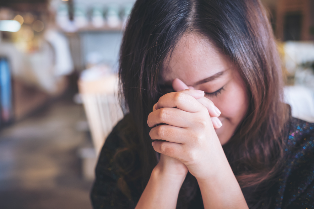 Woman praying and Trusting Jesus in Difficult Times