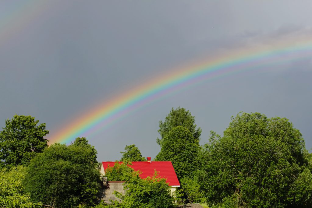 Rainbow over house and trees in sunshine. What are Promises of Hope in God?