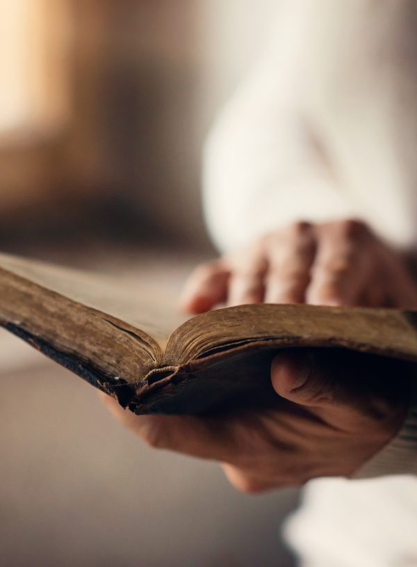 woman's hand on Bible while reading. How to Draw Closer to God by Reading His Word