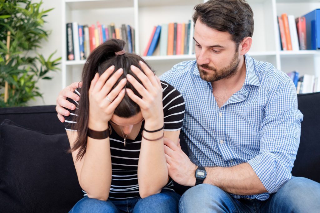 man comforting woman in living room. How to Pray When Life Feels Too Hard to Handle