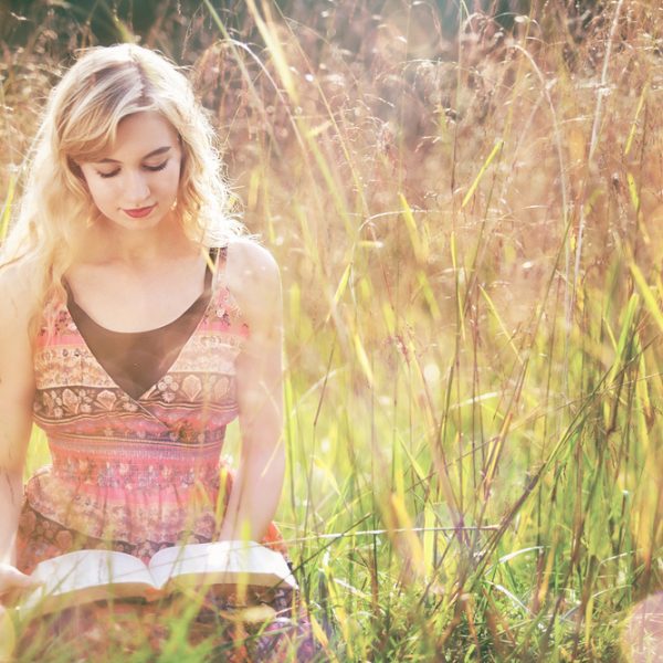 Women reading Bible in field on sunny day. Abiding in Christ: 7 Key Verses