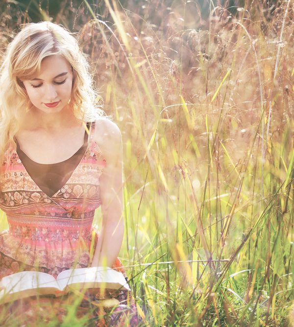 Women reading Bible in field on sunny day. Abiding in Christ: 7 Key Verses