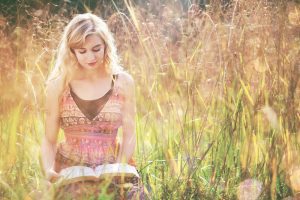 Women reading Bible in field on sunny day. Abiding in Christ: 7 Key Verses