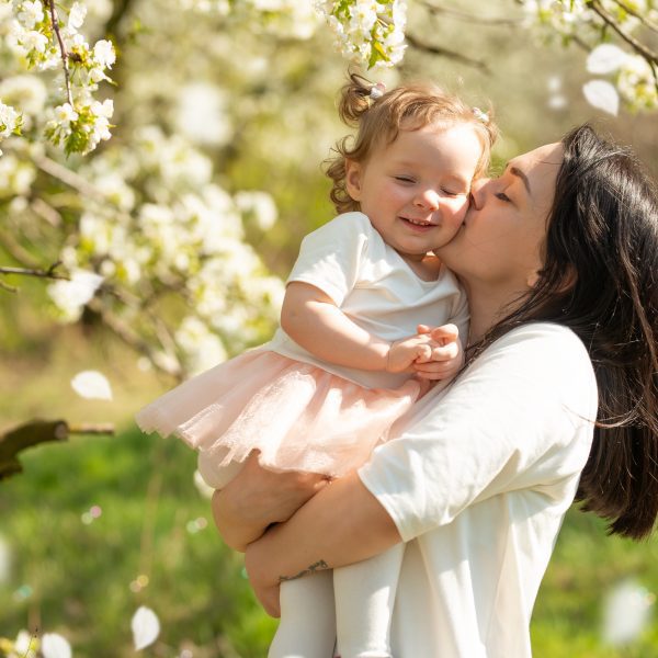 Mother and daughter in white with backgound of blooming tree of white flowers. Biblical Keys to Joy in Every Day Life