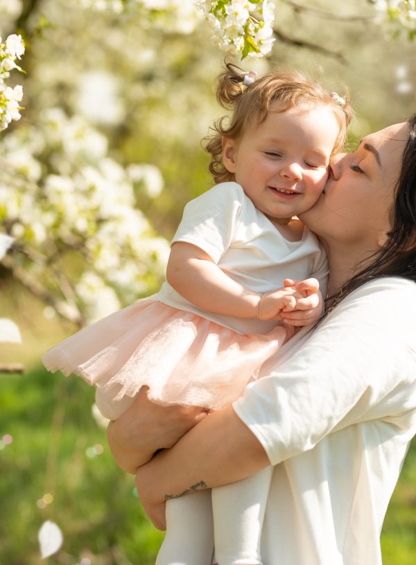 Mother and daughter in white with backgound of blooming tree of white flowers. Biblical Keys to Joy in Every Day Life