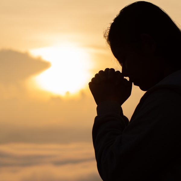 woman in shadow prayer in front of beach. Letting Go abd Trusting God: What Surrender Really Looks Like