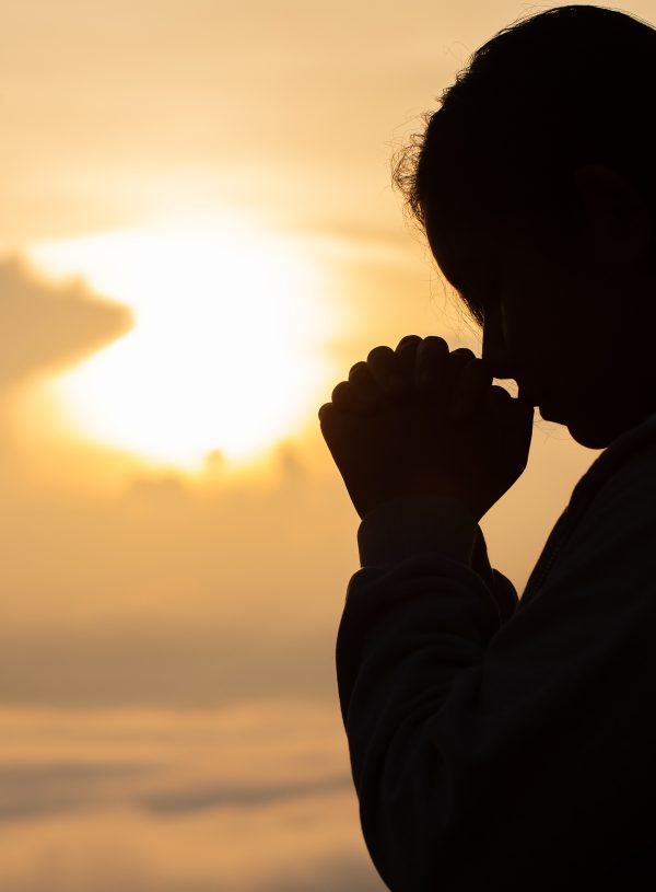 woman in shadow prayer in front of beach. Letting Go abd Trusting God: What Surrender Really Looks Like