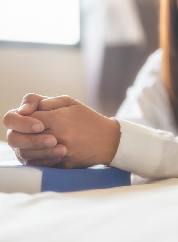 woman kneeling in prayer with Bible. 5 ways to build courage from god’s word for life’s daily battles