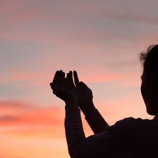woman in evening shadow praising God. Why Praise is Your Most Powerful Weapon in Difficult Seasons