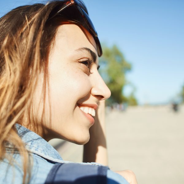 close up woman smiling in sunshine. 5 Unexpected Benefits of Doing God's Will Even Through Trials