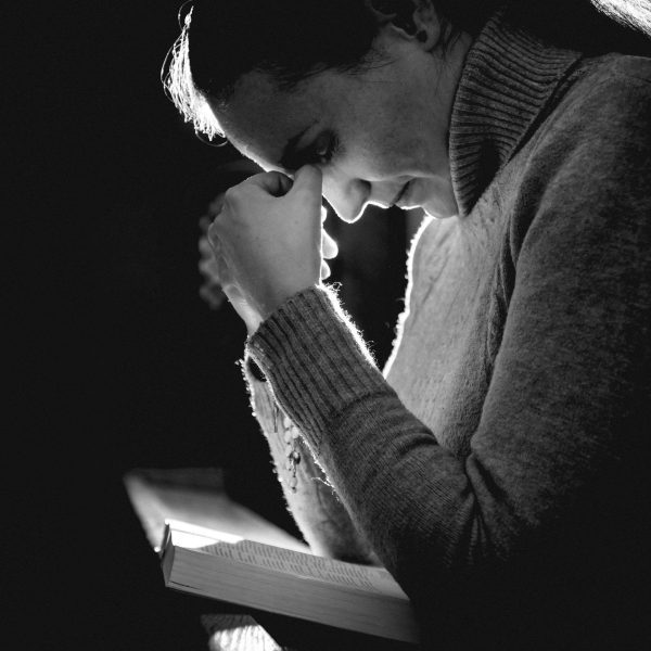 women bent over Bible in prayer. Prayers for Strength When You Feel Like Giving Up