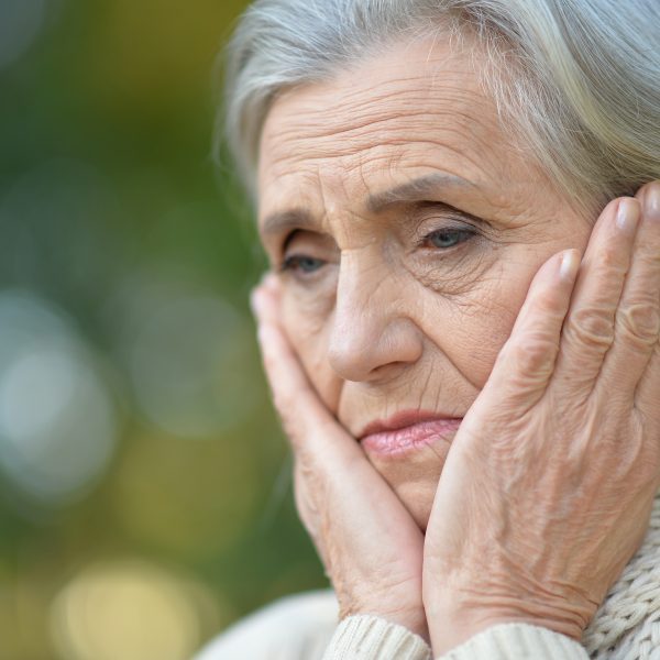 woman outside with hands on face looking discouraged. How to Believe God is Working When You Can't Hear Him