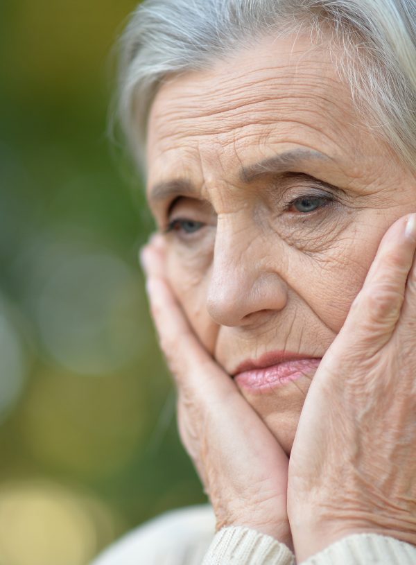 woman outside with hands on face looking discouraged. How to Believe God is Working When You Can't Hear Him